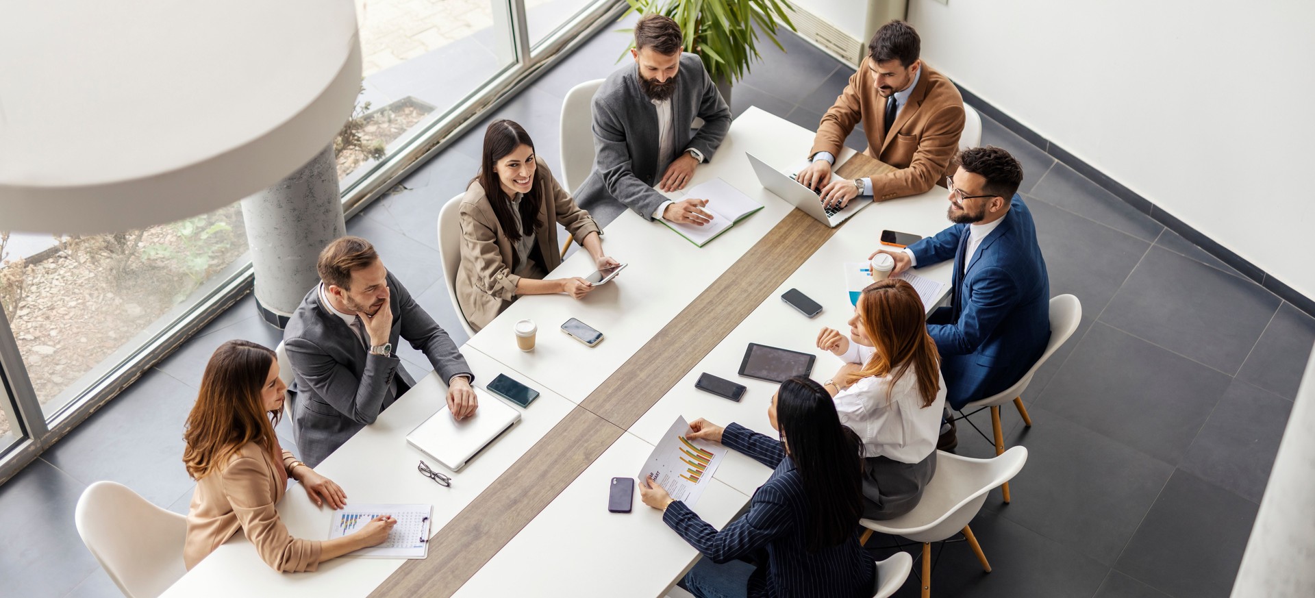 Top view of leadership team having meeting at boardroom at conference table.